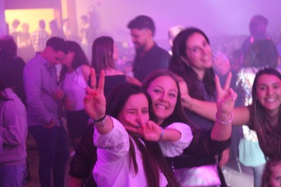 Scène couverte avec une table de mixage, des enceintes et une décoration florale, entourée de barrières de sécurité.