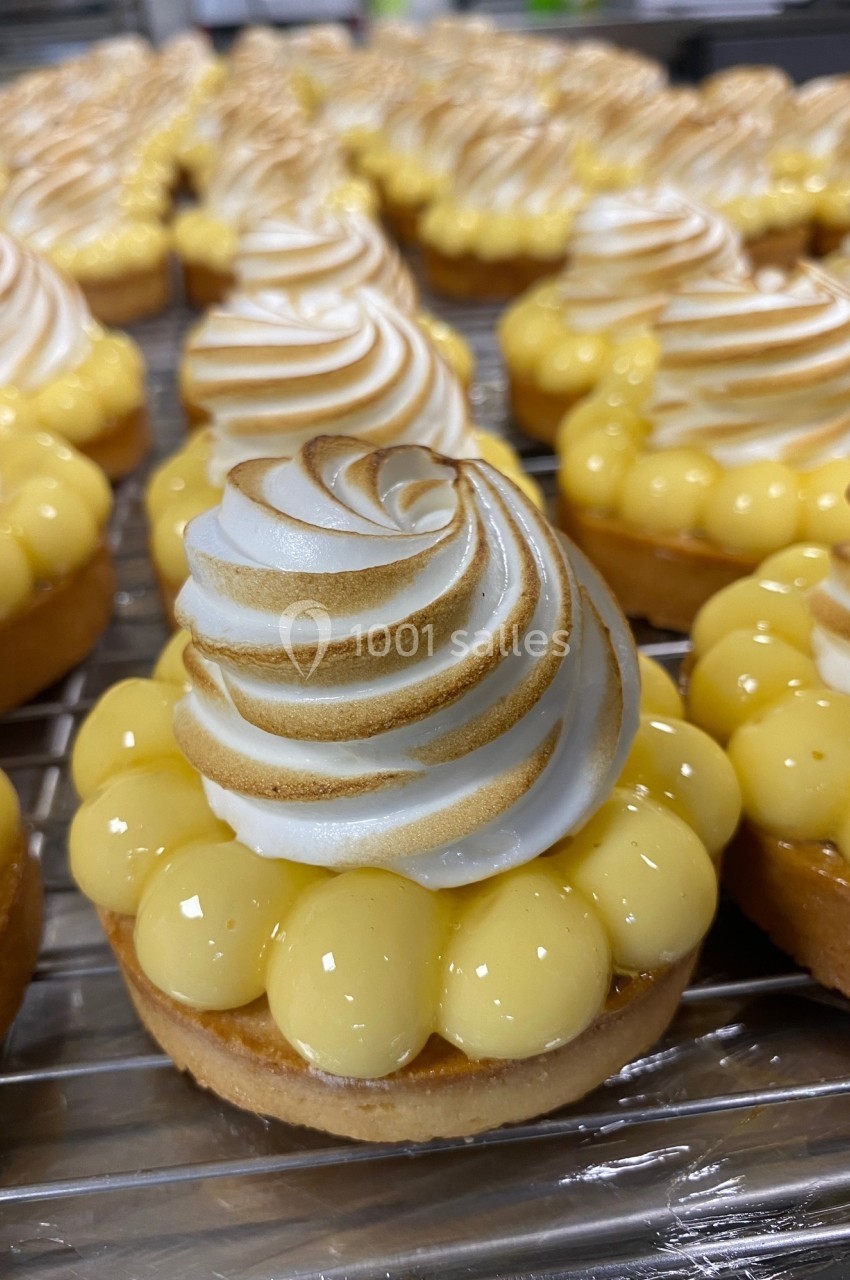 Tartelettes au citron garnies de meringue dorée, disposées sur une grille en cuisine.