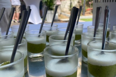 Miniature Traiteur Fréjus (Var) - La Cuisine By Alexandre #3 Salle de réception lumineuse avec tables rondes décorées de fleurs et vaisselle élégante, éclairée par des guirlandes.