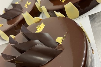 Miniature Traiteur Fréjus (Var) - La Cuisine By Alexandre #15 Salle de réception lumineuse avec tables rondes décorées de fleurs et vaisselle élégante, éclairée par des guirlandes.