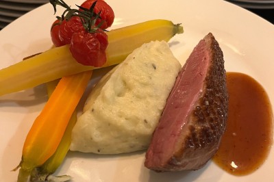 Miniature Traiteur Fréjus (Var) - La Cuisine By Alexandre #8 Salle de réception lumineuse avec tables rondes décorées de fleurs et vaisselle élégante, éclairée par des guirlandes.