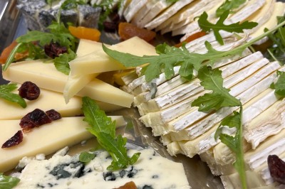 Miniature Traiteur Fréjus (Var) - La Cuisine By Alexandre #39 Salle de réception lumineuse avec tables rondes décorées de fleurs et vaisselle élégante, éclairée par des guirlandes.