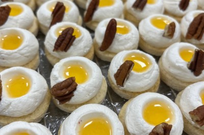 Miniature Traiteur Fréjus (Var) - La Cuisine By Alexandre #33 Salle de réception lumineuse avec tables rondes décorées de fleurs et vaisselle élégante, éclairée par des guirlandes.