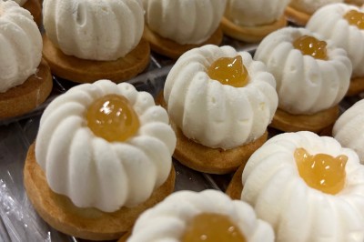 Miniature Traiteur Fréjus (Var) - La Cuisine By Alexandre #29 Salle de réception lumineuse avec tables rondes décorées de fleurs et vaisselle élégante, éclairée par des guirlandes.