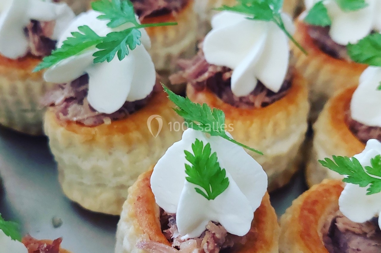 Bouchées feuilletées garnies de viande effilochée, crème décorative et feuilles de persil frais.