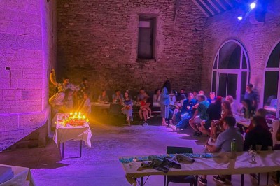 Cuisine professionnelle équipée avec plans de travail en inox, four, hotte d'extraction et portes en bois.