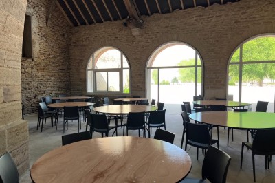 Cuisine professionnelle équipée avec plans de travail en inox, four, hotte d'extraction et portes en bois.