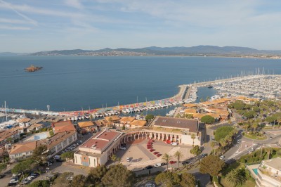 Une chanteuse en robe dorée se produit sur scène, entourée d'un chœur en tenues assorties, sous un éclairage bleu.