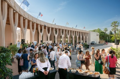 Une chanteuse en robe dorée se produit sur scène, entourée d'un chœur en tenues assorties, sous un éclairage bleu.