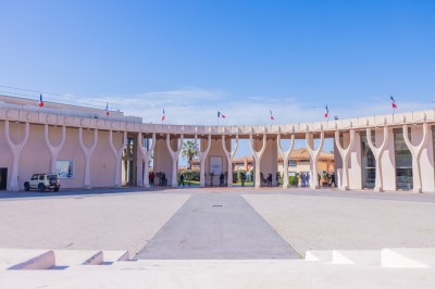 Une chanteuse en robe dorée se produit sur scène, entourée d'un chœur en tenues assorties, sous un éclairage bleu.