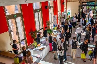 Une chanteuse en robe dorée se produit sur scène, entourée d'un chœur en tenues assorties, sous un éclairage bleu.