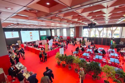 Une chanteuse en robe dorée se produit sur scène, entourée d'un chœur en tenues assorties, sous un éclairage bleu.