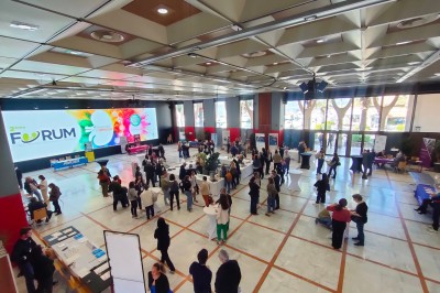 Une chanteuse en robe dorée se produit sur scène, entourée d'un chœur en tenues assorties, sous un éclairage bleu.