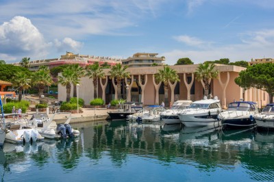 Une chanteuse en robe dorée se produit sur scène, entourée d'un chœur en tenues assorties, sous un éclairage bleu.