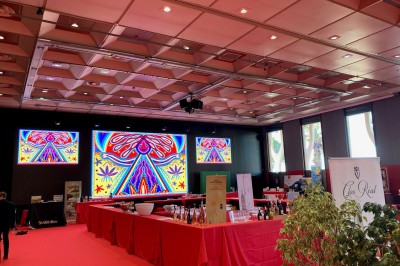 Une chanteuse en robe dorée se produit sur scène, entourée d'un chœur en tenues assorties, sous un éclairage bleu.