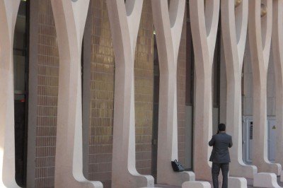 Une chanteuse en robe dorée se produit sur scène, entourée d'un chœur en tenues assorties, sous un éclairage bleu.