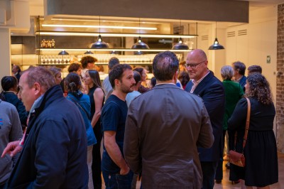 Salle moderne avec plafond végétalisé, éclairage violet, mobilier minimaliste et sol recouvert de tapis vert.