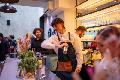 Salle moderne avec plafond végétalisé, éclairage violet, mobilier minimaliste et sol recouvert de tapis vert.