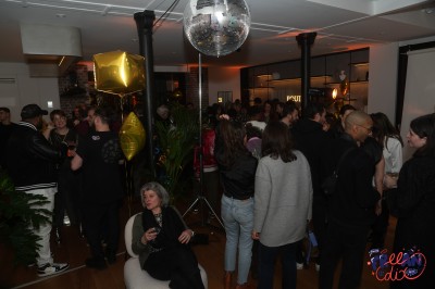 Salle moderne avec plafond végétalisé, éclairage violet, mobilier minimaliste et sol recouvert de tapis vert.