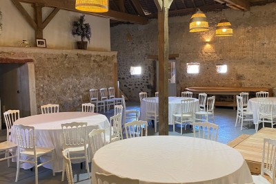 Cuisine rustique avec murs en pierre, poutres apparentes, meubles en bois et appareils électroménagers modernes.