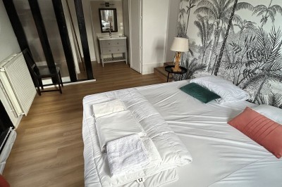 Cuisine rustique avec murs en pierre, poutres apparentes, meubles en bois et appareils électroménagers modernes.