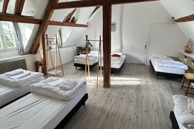 Cuisine rustique avec murs en pierre, poutres apparentes, meubles en bois et appareils électroménagers modernes.