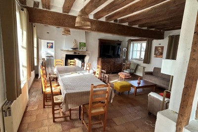 Cuisine rustique avec murs en pierre, poutres apparentes, meubles en bois et appareils électroménagers modernes.