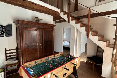 Cuisine rustique avec murs en pierre, poutres apparentes, meubles en bois et appareils électroménagers modernes.