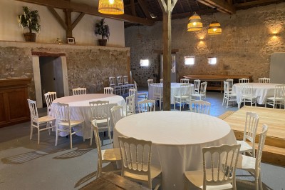 Cuisine rustique avec murs en pierre, poutres apparentes, meubles en bois et appareils électroménagers modernes.