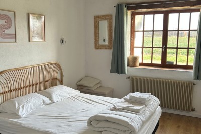 Cuisine rustique avec murs en pierre, poutres apparentes, meubles en bois et appareils électroménagers modernes.