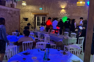 Cuisine rustique avec murs en pierre, poutres apparentes, meubles en bois et appareils électroménagers modernes.