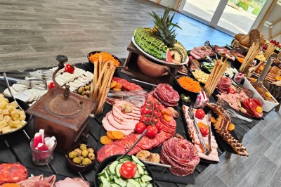 Plateau de bouchées apéritives variées comprenant verrines, choux garnis et feuilletés, disposés sur une table.