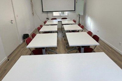 Miniature Salle de Sycomore Des personnes debout dans une salle décorée, tenant des verres, devant des tables dressées pour une fête.