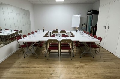 Miniature Salle des Saules Des personnes debout dans une salle décorée, tenant des verres, devant des tables dressées pour une fête.