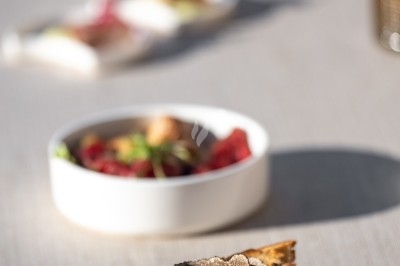 Logo ’OFYR’ gravé sur une surface métallique sombre et texturée.