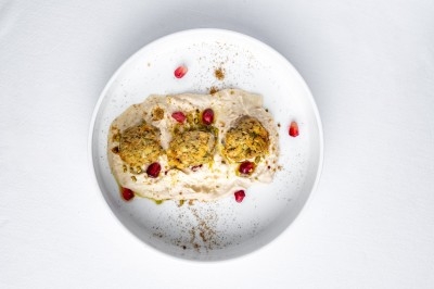 Logo ’OFYR’ gravé sur une surface métallique sombre et texturée.