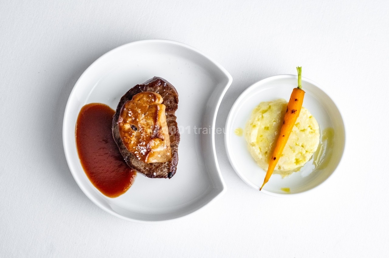 Assiette avec un filet de viande, sauce, foie gras, purée de pommes de terre et une carotte entière.