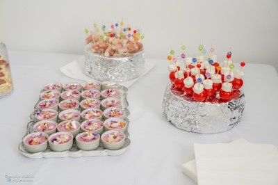 Table dressée avec une assiette blanche, une serviette rose ornée d'une feuille argentée, et des couverts cuivrés.