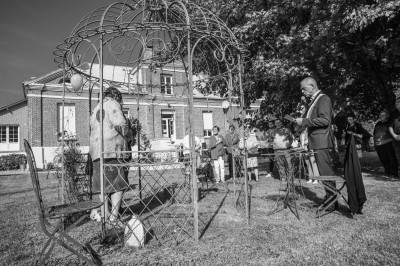 Table dressée avec une assiette blanche, une serviette rose ornée d'une feuille argentée, et des couverts cuivrés.
