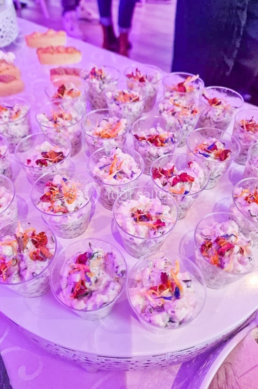 Petites verrines garnies d'une préparation crémeuse aux légumes et décorées de fleurs comestibles colorées.