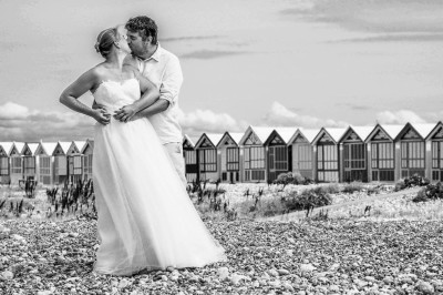 Table dressée avec une assiette blanche, une serviette rose ornée d'une feuille argentée, et des couverts cuivrés.