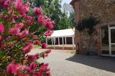 Miniature Location salle Montilliers (Maine-et-Loire) - Le Parc de Tirpoil #24 Cuisine professionnelle avec carrelage blanc, plan de travail en inox, évier, cuisinière et hotte.