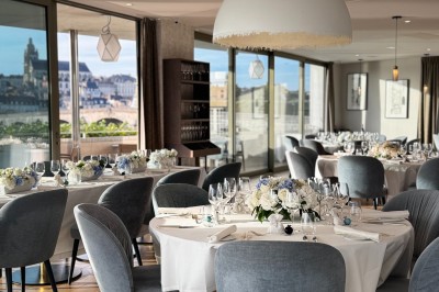 Assiette blanche contenant une présentation soignée de fraises, feuilles et sauce rouge sur un motif doré.