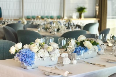 Assiette blanche contenant une présentation soignée de fraises, feuilles et sauce rouge sur un motif doré.