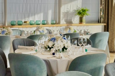 Assiette blanche contenant une présentation soignée de fraises, feuilles et sauce rouge sur un motif doré.