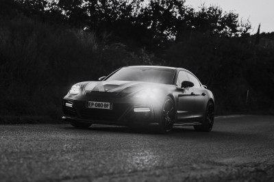Salle de réception spacieuse avec tables rondes dressées, chaises blanches et éclairage doux.