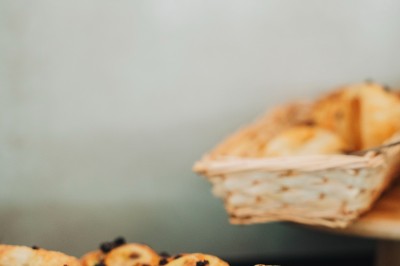 Salle de réception spacieuse avec tables rondes dressées, chaises blanches et éclairage doux.