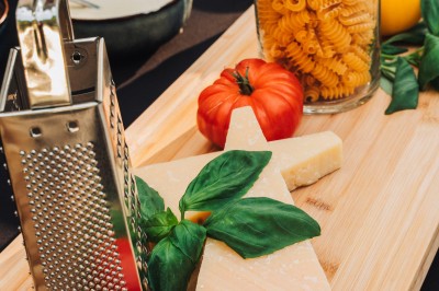 Salle de réception spacieuse avec tables rondes dressées, chaises blanches et éclairage doux.