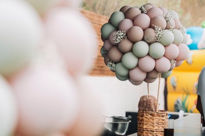 Salle de réception spacieuse avec tables rondes dressées, chaises blanches et éclairage doux.