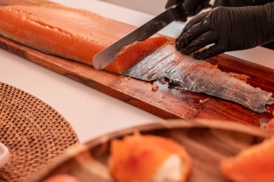 Salle de réception spacieuse avec tables rondes dressées, chaises blanches et éclairage doux.